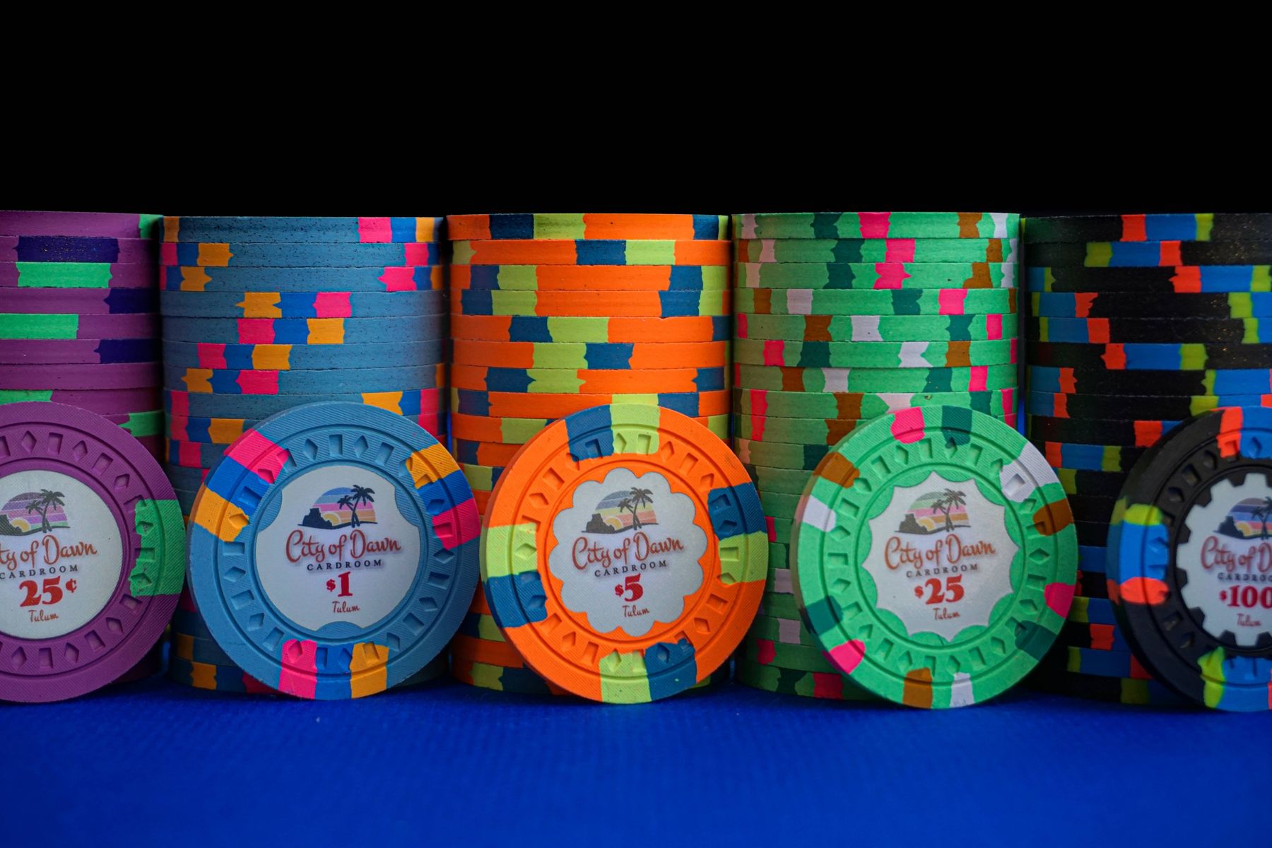 Close-up of custom City of Dawn cardroom chips with multicolor edge spots