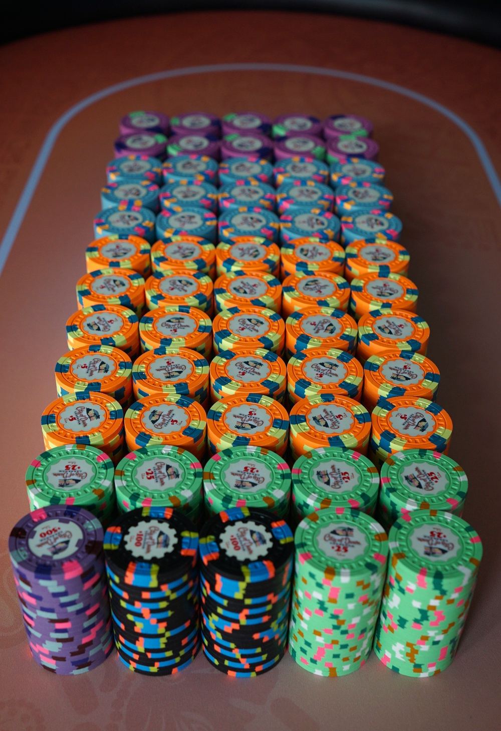 A full custom cardroom set laid out in stacks on a poker table